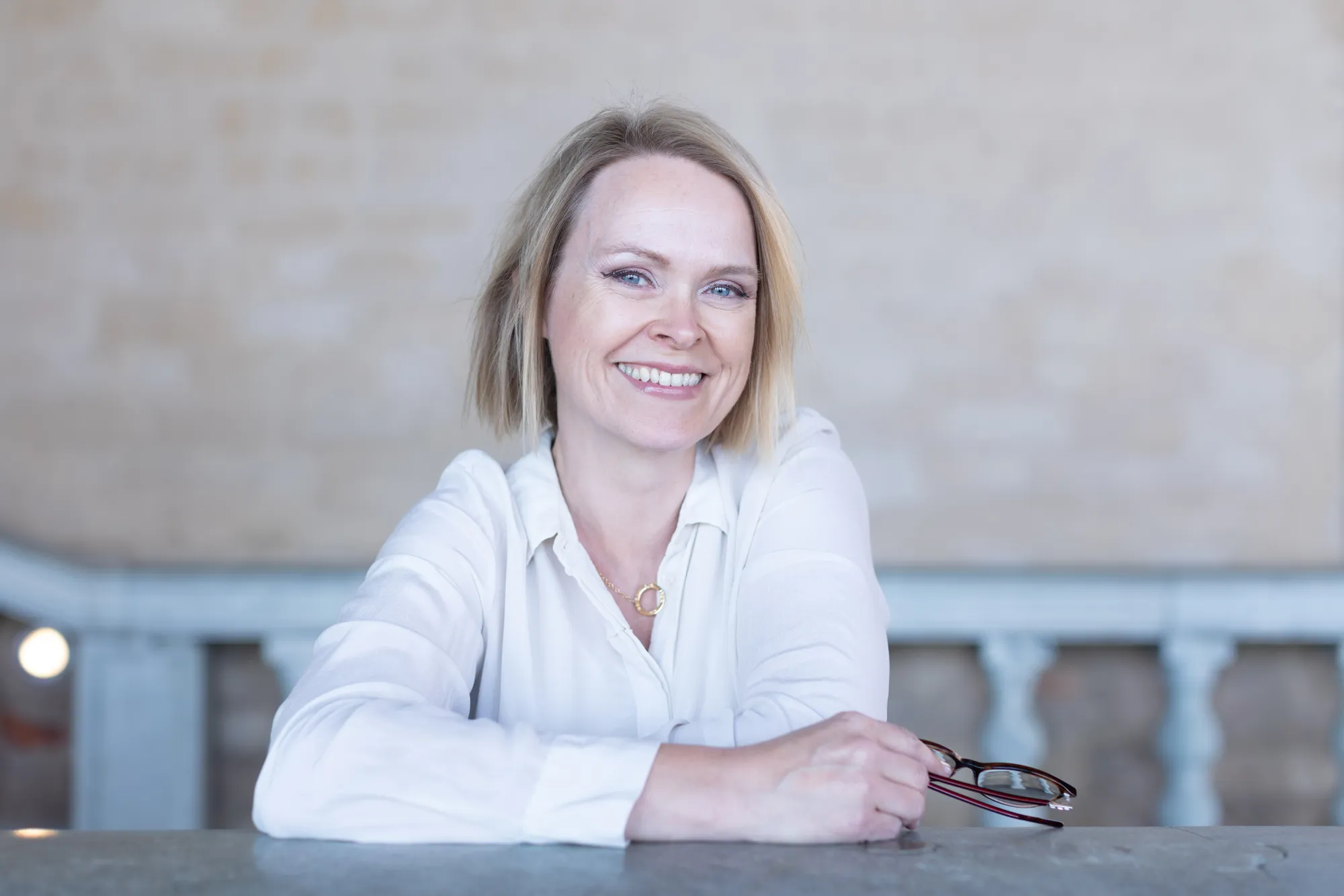 Dr Alette sitter på en stol inför en föreläsning